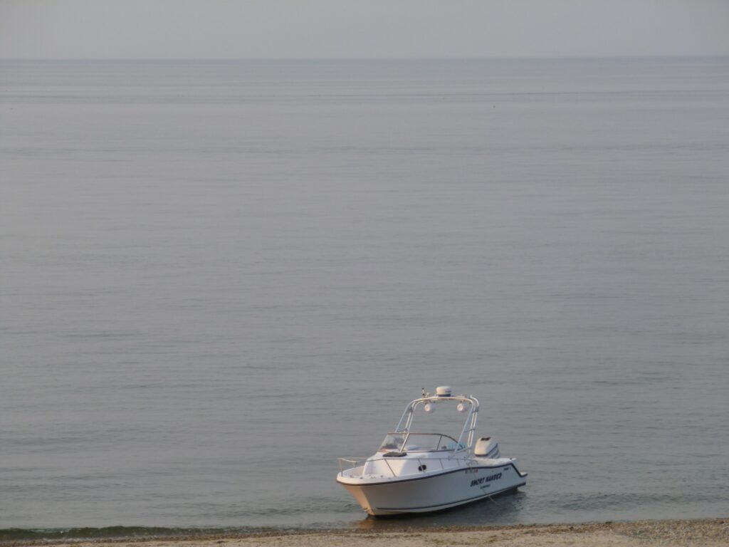 Picture of a white boat near the beach shore.